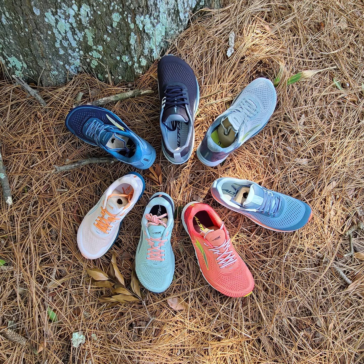 A selection of running shoes from multiple brands arranged on Lowcountry pine straw