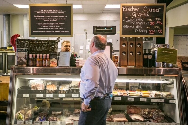 A customer at Ted's Butcherblock butcher counter