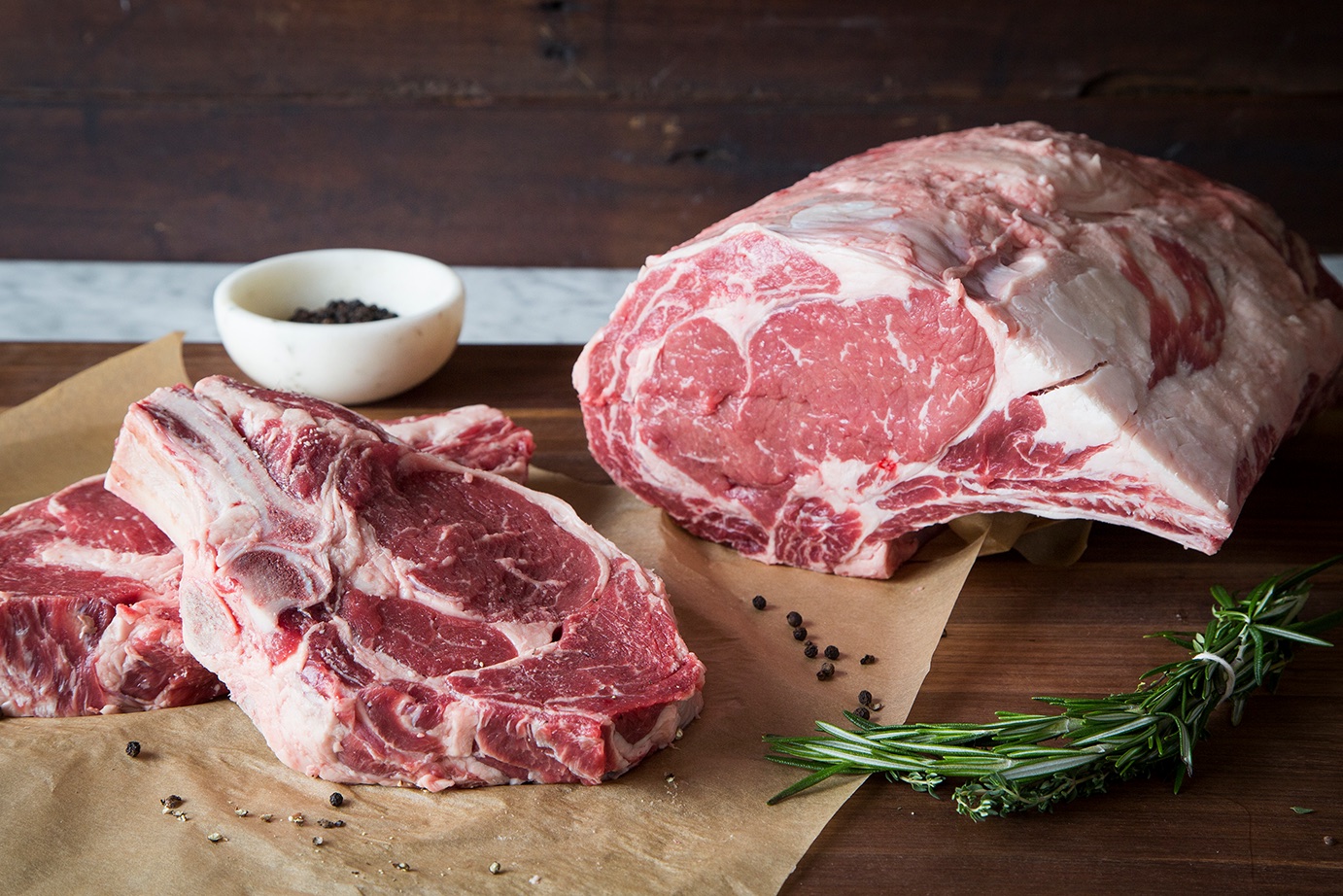 Bone-in ribeyes and a rib roast on butcher paper at Ted's Butcherblock